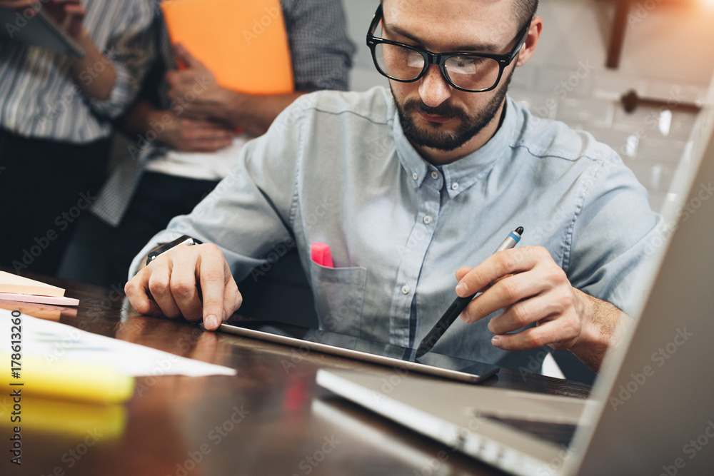 Bearded businessman in glasses plans spending business on tablet while sitting at home in kitchen. Trader working market report on touching screen tablet Bearded businessman in glasses plans spending business on tablet while sitting at home in kitchen. Trader working market report on touching screen tablet