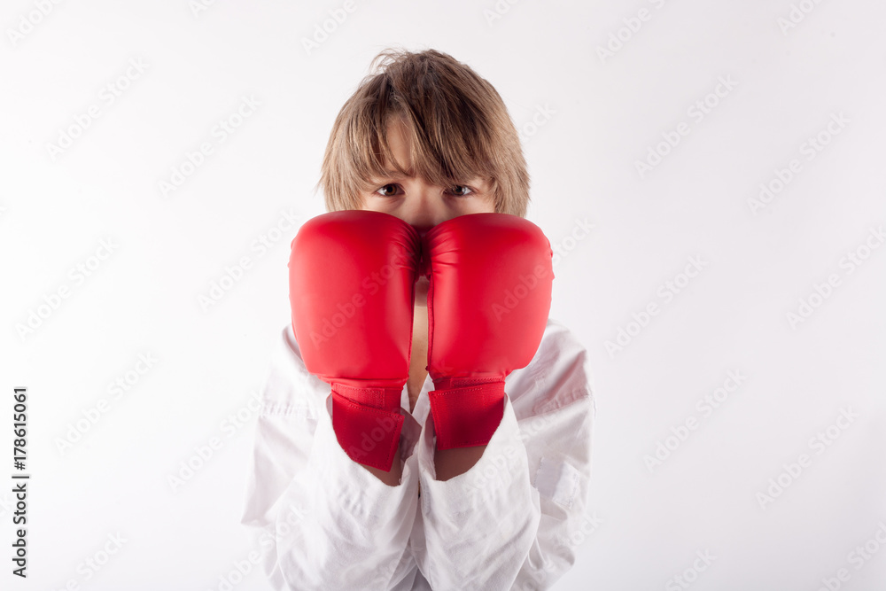 Portrait of a karate kid wearing red boxing gloves Portrait of a karate kid wearing red boxing gloves