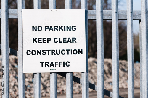 Sign warning public not to park at a gate as it is needed to be kept clear for construction traffic.