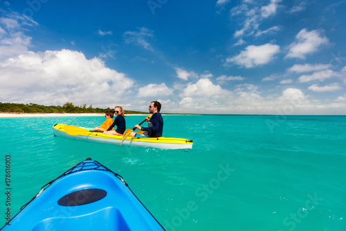 Family kayaking at tropical ocean