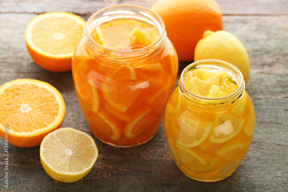 Lemon and orange jam in glass jars on wooden table Lemon and orange jam in glass jars on wooden table