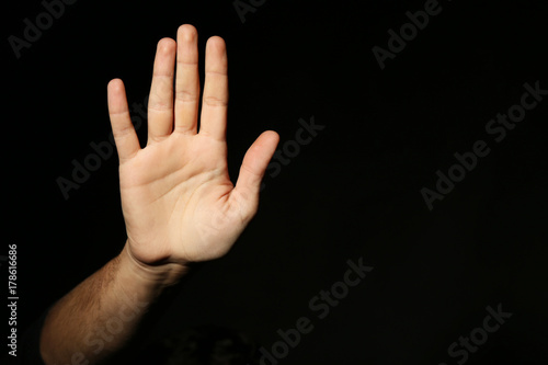 Male hand on a black background