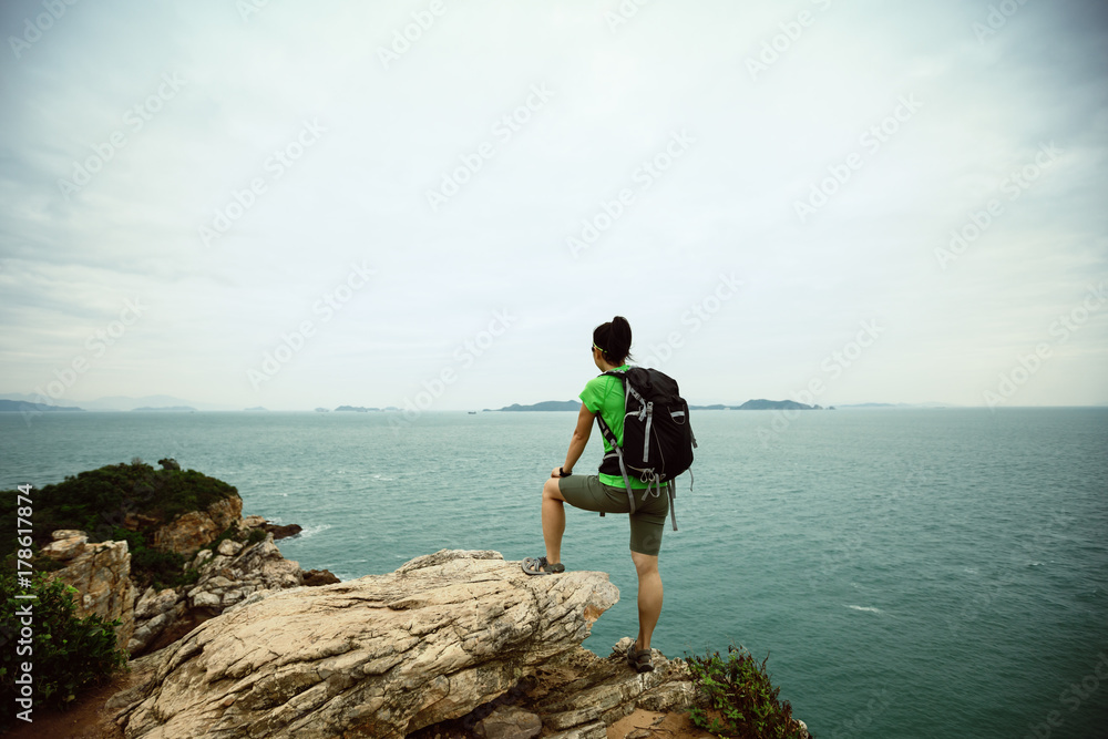 woman backpacker enjoy the view on seaside mountain top cliff woman backpacker enjoy the view on seaside mountain top cliff