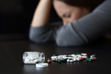 Depressed woman beside a lot of pills