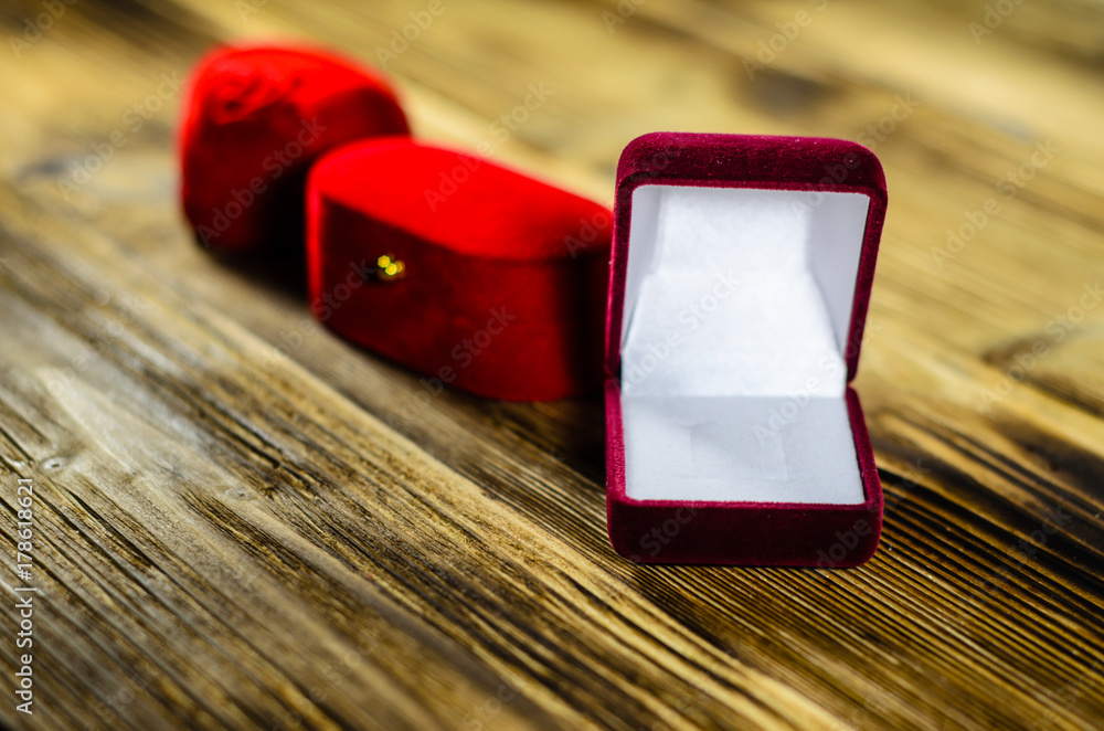 Different red jewelry boxes on wooden table Different red jewelry boxes on wooden table