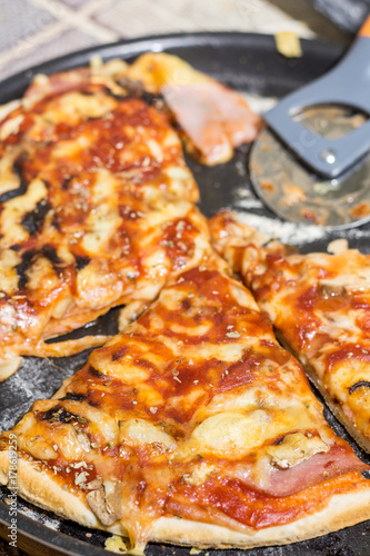 Świeża pieczona i pokrojona pizza z pieczarkami, szynką i serem