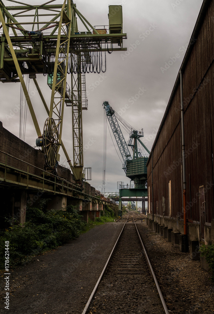 Dark harbour with cranes and train rails Dark harbour with cranes and train rails