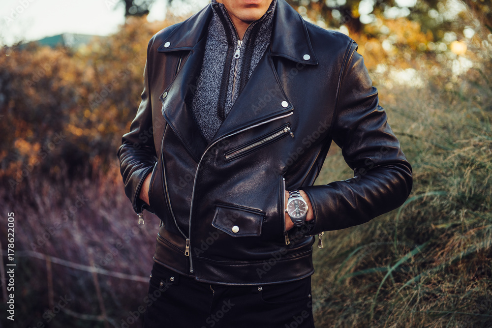 Man wearing black leather jacket and watch posing outdoors Stock Photo ...