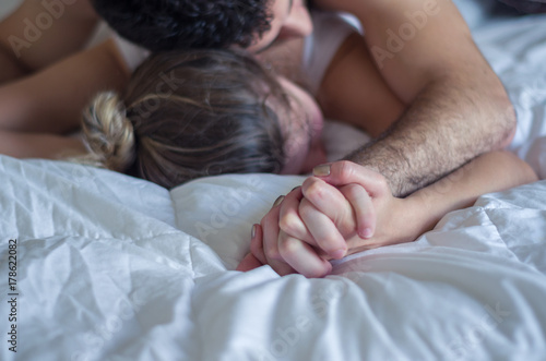 ótimo conceito de orgasmo, sexo, sem vulgaridade, homem segurando mão de mulher na cama photo