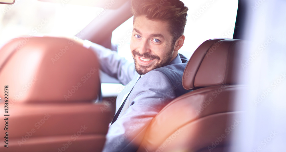 Portrait of an handsome smiling business man driving his car Portrait of an handsome smiling business man driving his car
