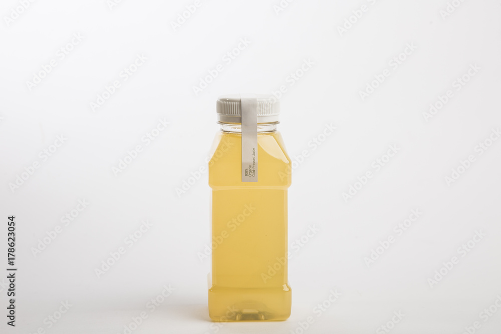 Fresh ginger juice in plastic bottle. White background. Organic nutrition. Detox juice. Small size bottle Fresh ginger juice in plastic bottle. White background. Organic nutrition. Detox juice. Small size bottle