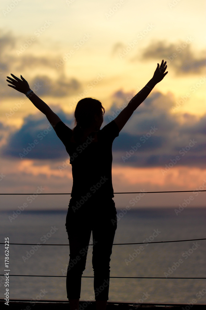 Fototapeta premium Silhouettle woman standing on hill with sunset