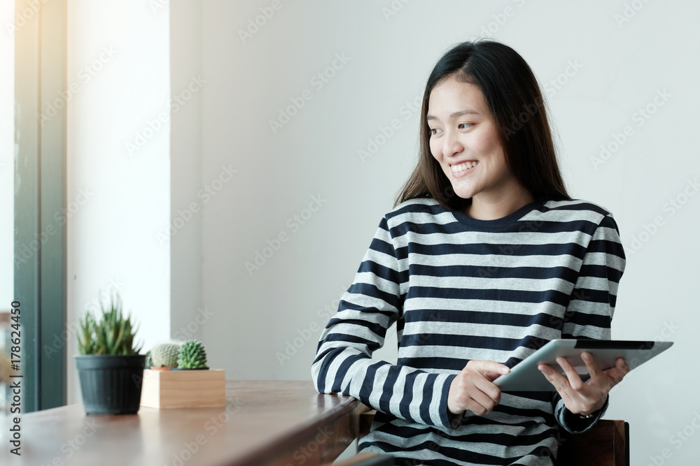 Young asian woman using tablet while sitting in cafe background, People technology and lifestyle Young asian woman using tablet while sitting in cafe background, People technology and lifestyle