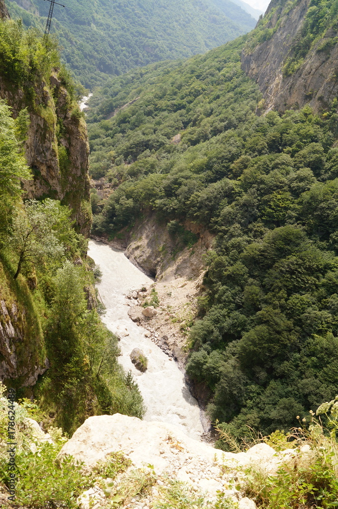 Obraz premium Clean fast river surrounded by mountains, landscape on a sunny day.