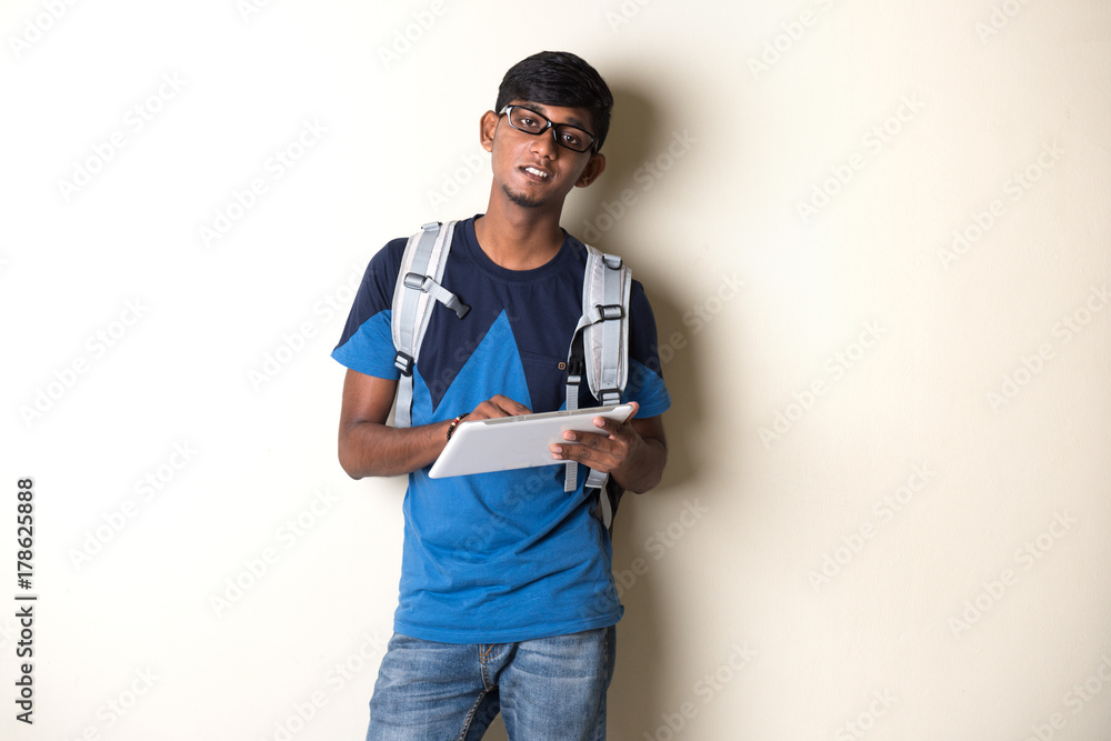 indian teenage male on tablet computer indian teenage male on tablet computer