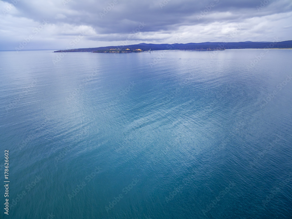 Minimalist aerial landscape - nothing but water, patch of land, and skies Minimalist aerial landscape - nothing but water, patch of land, and skies