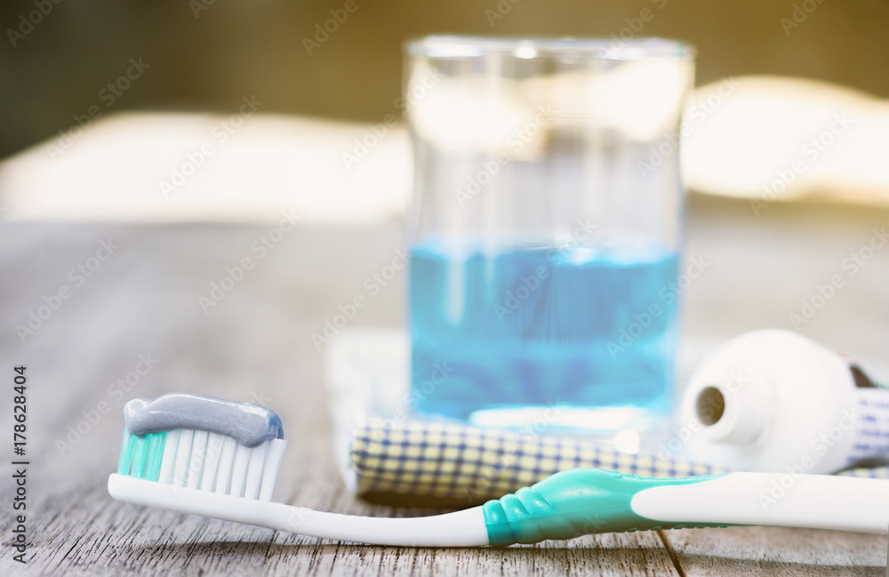 Toothbrush with toothpaste and mouthwash on wooden table. Toothbrush with toothpaste and mouthwash on wooden table.