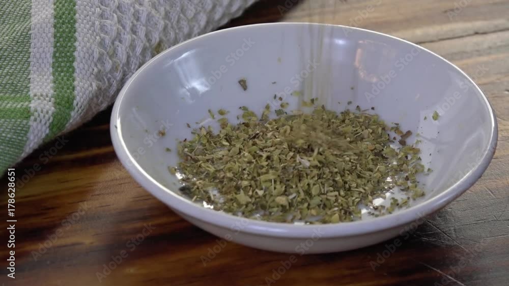Pouring oregano into a spice dish slow motion
Pouring oregano into a spice dish slow motion