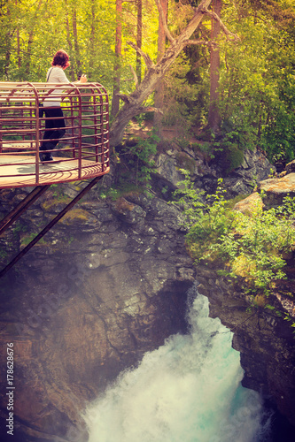 Tourist with camera on Gudbrandsjuvet waterfall, Norway photo