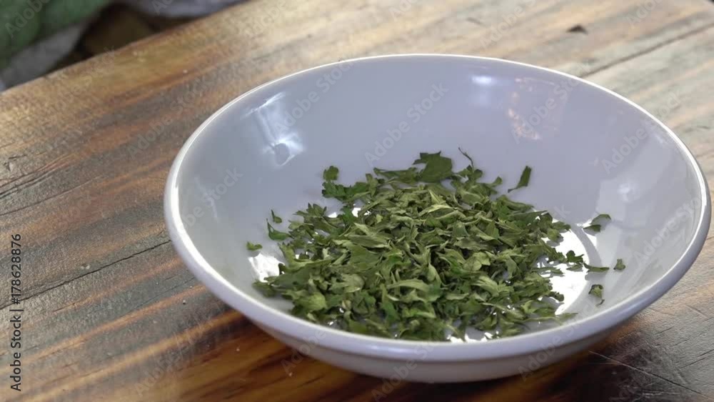 Pouring parsley into a dish, slow motion Pouring parsley into a dish, slow motion