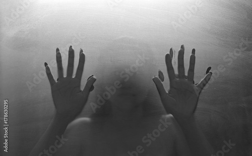 person shadows on Frosted glass - violence concept background.