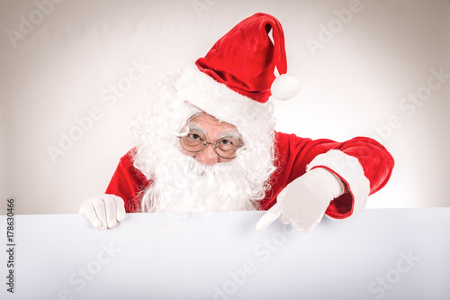 Merry christmas,Santa Claus pointing in white blank sign,Isolated on white background. © kasipat