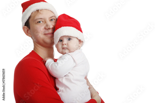 Father with his baby in Santa hat celebrating Christmas. In Studio on white background isolated