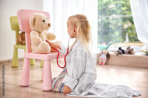 Little girl in medical coat...