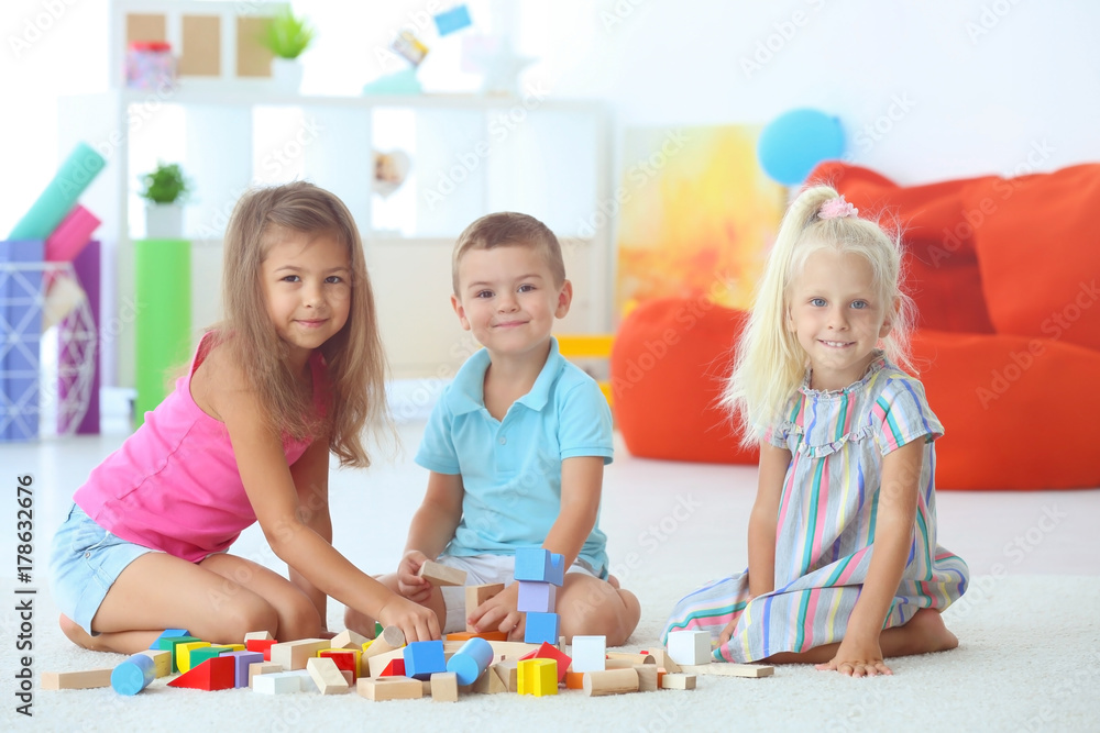 Fototapeta premium Cute children playing with blocks indoor