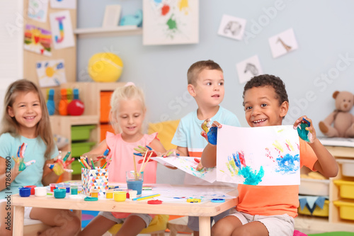 Fényképezés Cute children painting with their palms at table indoor