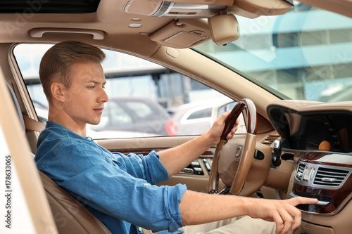 Young man on driver seat of...
