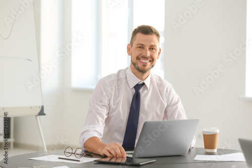 Young male professional working at table in office