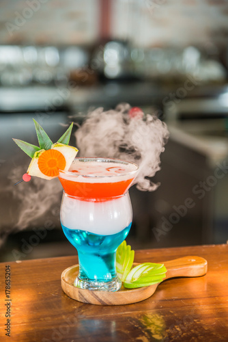 Cocktail drink with smoke decorated with some sliced green apple