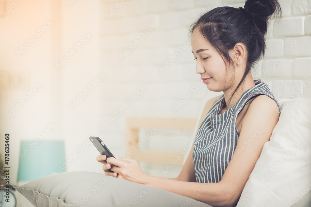 Happy asian girl reading smart phone with smile face on bed . Happy asian girl reading smart phone with smile face on bed .
