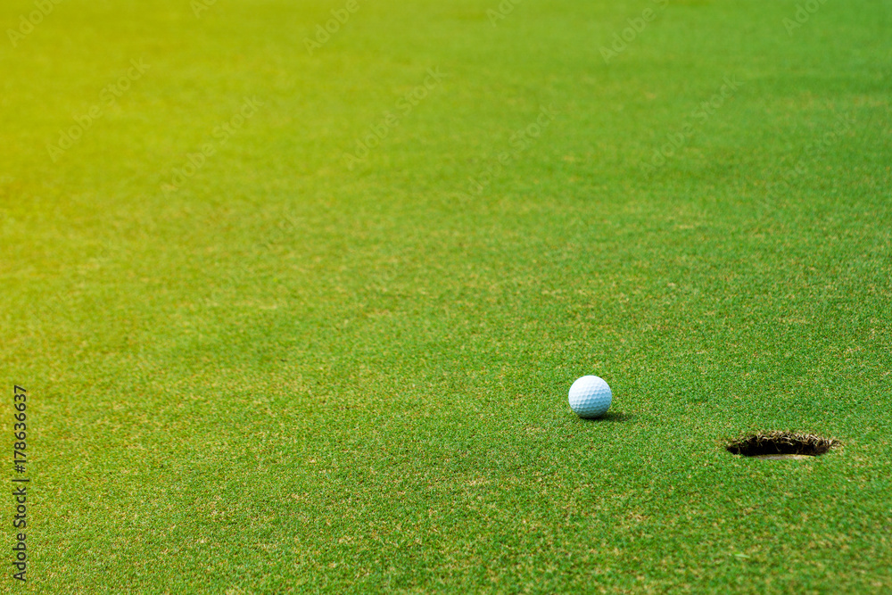 Golf ball on green near golf hole Concept of success, win	