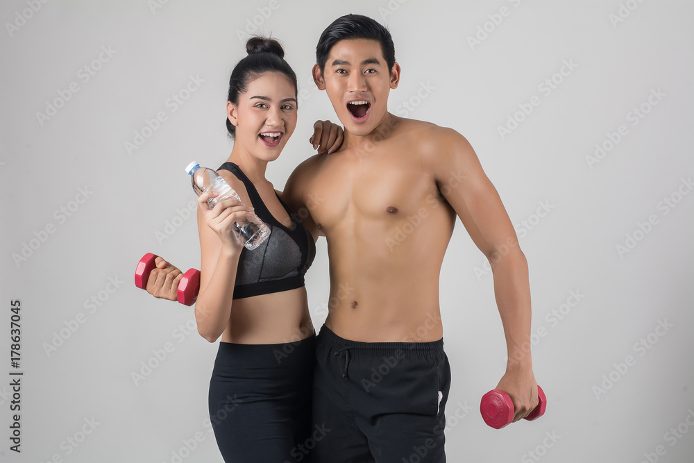 Muscular couple showing six pack abs isolated on white background. Muscular couple showing six pack abs isolated on white background.