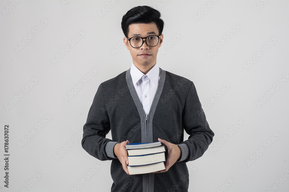 Young nerd man wearing glasses holding a book stack while standing isolated on white background. Young nerd man wearing glasses holding a book stack while standing isolated on white background.