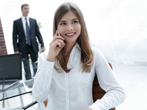 closeup.female assistant talking on mobile phone in office