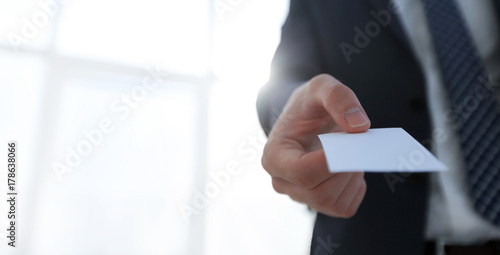 Business man giving business card on bright background