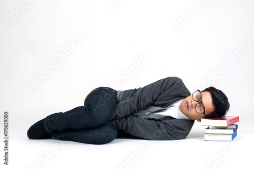Playful happy young man funny round glasses lying with book over white background © Johnstocker