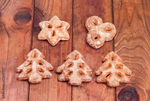 Festive gingerbreads in different shapes on a wooden surface