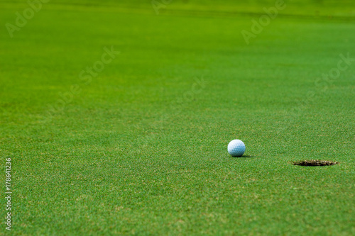 Golf ball on green near golf hole Concept of success, win