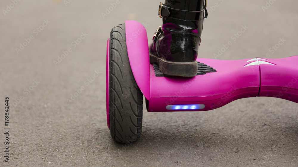 Child on hover board. Kids riding scooter in park. Balance board for  children. Electric self balancing scooter on city street. Girl learning to  ride hoverboard. Modern gadgets for school kid. Stock Photo