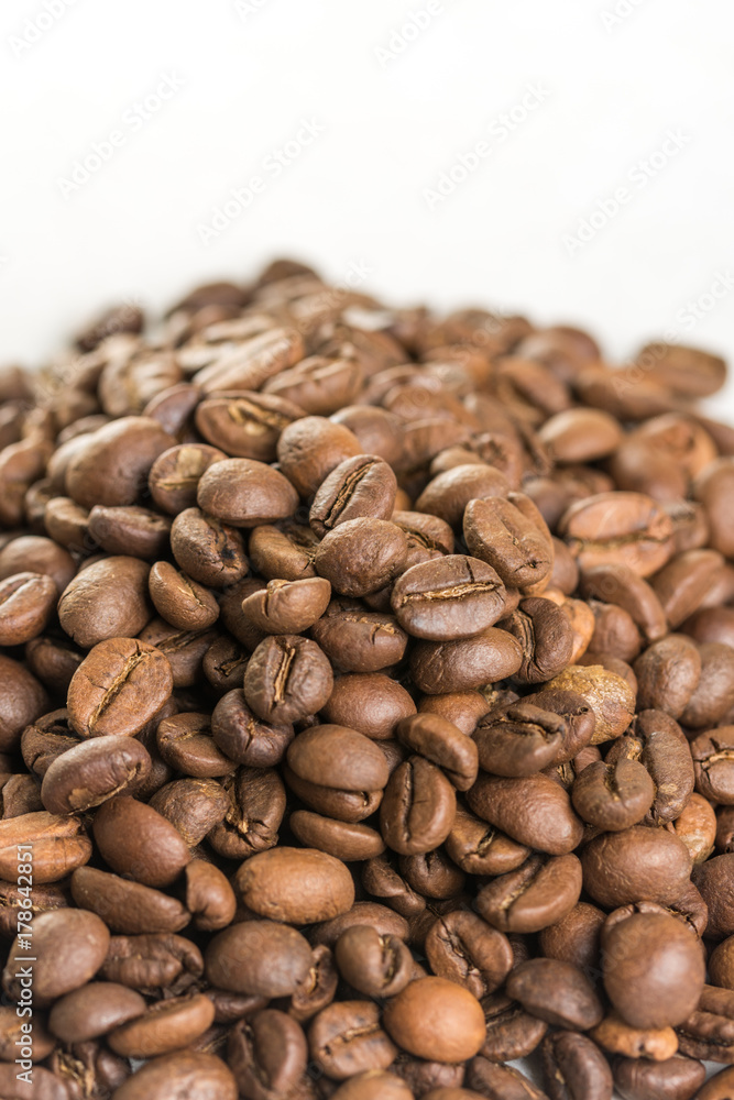 Pile of coffee beans isolated above white marble background Pile of coffee beans isolated above white marble background