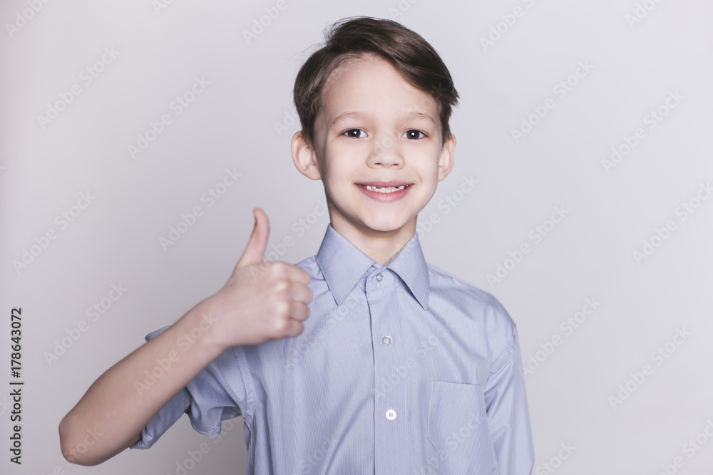 Portrait of cheerful brunette boy showing thumb up gesture, isolated. Portrait of cheerful brunette boy showing thumb up gesture, isolated.