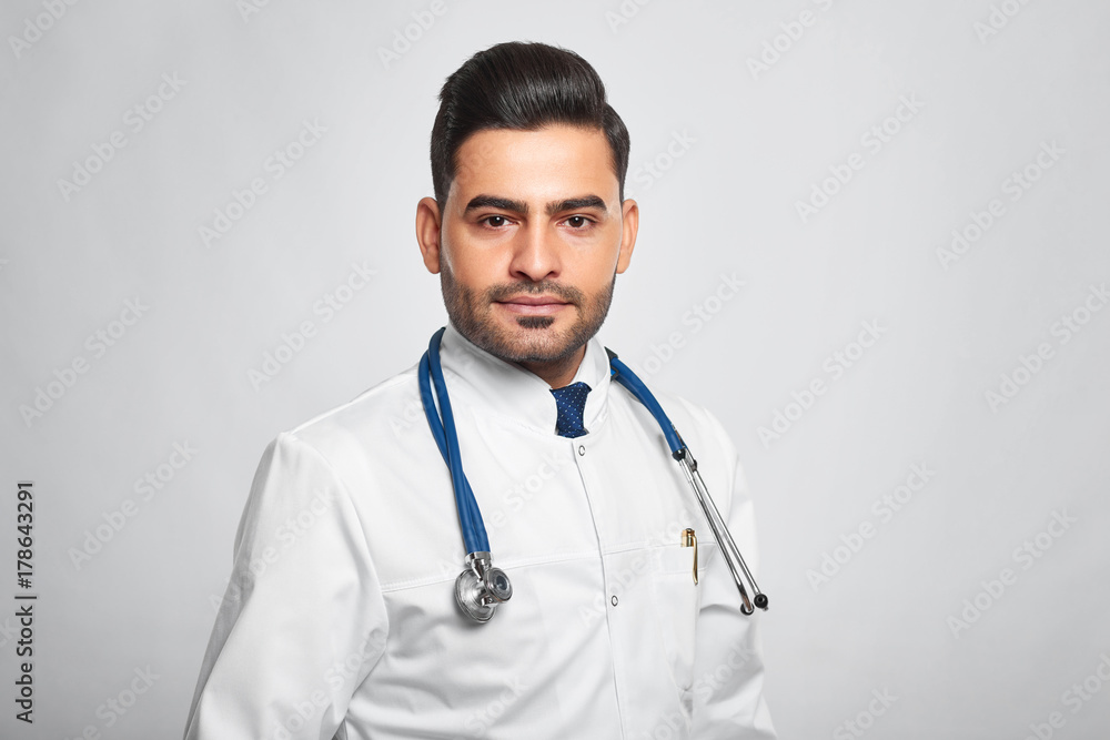 Horizontal studio portrait of a young male doctor wearing labcoat and stethoscope posing on grey background copyspace profession occupation job professionalismsuccess confidence scientist health. Horizontal studio portrait of a young male doctor wearing labcoat and stethoscope posing on grey background copyspace profession occupation job professionalismsuccess confidence scientist health.