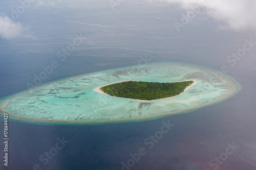 Tropical islands and atolls in Maldives in Indian Ocean from aerial view. Piece of paradise on the Earth. Good choice for vacation. Beautiful top view for wallpaper.