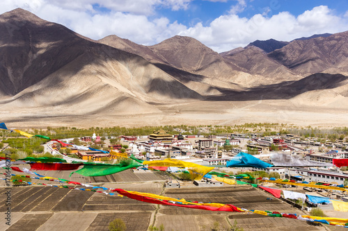 Top view of Samye monastery, with prayer flags in foreground and himalaya range in background - Tibet photo