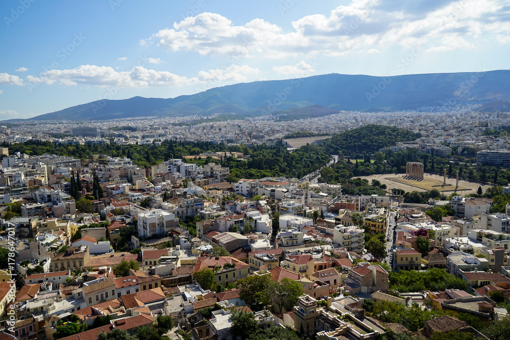 Panoramic view of Athens city from Acropolis seeing ancient ruin, building architecture, trees, mountain and bright sky background
