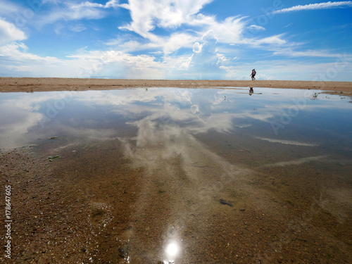 some one walking on the beach with puddle